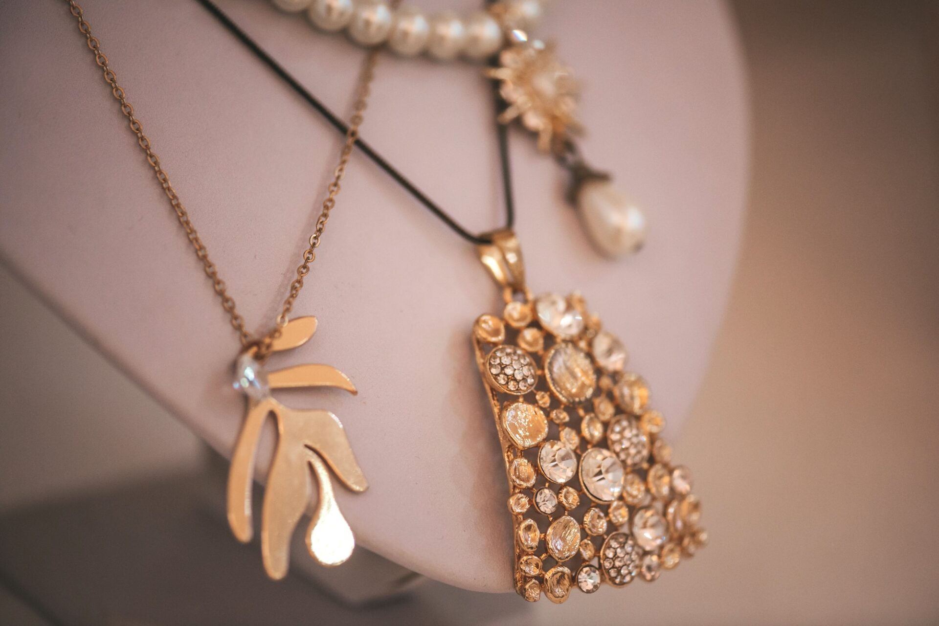 Luxury gold jewelry on set holders and in jewelry box on light dressing table and wardrobe shelves